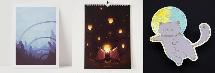 An art print of a landscape in pixel art style, a wall calendar with two birds and skylanterns and a holographic astronaut cat sticker